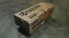 A cardboard box for a Kyocera toner cartridge sits on a concrete floor. Podgląd zdjęcia produktu