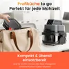 A hand is placing a food container into a tote bag next to a compact air fryer. Produktbild-Vorschau