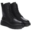 A pair of black leather lace-up boots with thick soles, shown from a slightly angled front view against a white background. Podgląd zdjęcia produktu