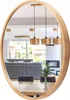 A round mirror with a wooden frame reflects a dining area and living room. Produktbild-Vorschau