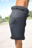 A close-up of a black horse leg brace on a horse's leg, with a blurred background of a rural setting. Produktbild-Vorschau