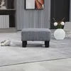 A gray upholstered ottoman sits on a gray rug in a living room setting. Produktbild-Vorschau