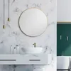 A modern bathroom with a marble wall, a round gold mirror, a white sink, and a green accent wall with a bathtub. Podgląd zdjęcia produktu