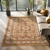 A Persian-style rug is placed in a modern living room setting, next to a sofa and a coffee table with decorative items. Produktbild-Vorschau