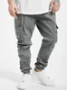 A person wearing grey cargo jogging pants and white sneakers. Produktbild-Vorschau