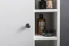 A close-up view of a white cabinet with a silver knob, revealing shelves inside containing various toiletries and cosmetic products. Náhled obrázku produktu