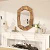 A decorative mirror above a fireplace with a bust and a small golden figurine on the mantelpiece. Produktbild-Vorschau