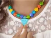 A close-up shot of a person's neck and chest wearing a colorful beaded necklace with a pizza-shaped pendant. Anteprima dell’immagine prodotto
