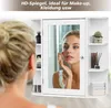 A woman is looking in a mirror of a white cabinet, applying makeup. Produktbild-Vorschau