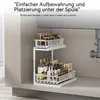 A two-tier sliding organizer filled with bottles and jars placed under a sink. Voir les images du produit