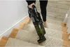 A person is vacuuming a carpeted staircase with a handheld vacuum cleaner. Produktbild-Vorschau
