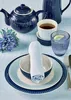 A table setting with a teapot, teacup, and plates, decorated with a blue flower. Produktbild-Vorschau