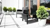 A balcony with outdoor furniture and potted plants. Produktbild-Vorschau