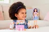 A young girl is playing with a Barbie Skipper doll and accessories, including a baby doll, crib, and teddy bear. Podgląd zdjęcia produktu