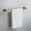 A white towel hanging on a copper towel rack mounted on a gray wall. Anteprima dell’immagine prodotto