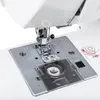 Close-up view of the needle and presser foot area of a white sewing machine. Produktbild-Vorschau