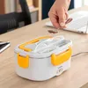 A hand is holding a spoon over an electric lunch box on a wooden desk, with a laptop in the background. Produktbild-Vorschau