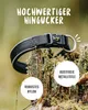 A dog collar is shown resting on a moss-covered tree stump in a natural outdoor setting. Produktbild-Vorschau