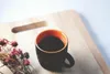 A cup of coffee and dried flowers on a wooden cutting board. Podgląd zdjęcia produktu