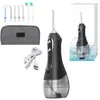 A collection of items related to a cordless water flosser, including the device itself, various nozzles, a charging cable, and a storage pouch, all arranged on a white background. A box with an image of the product is also visible. Voir les images du produit