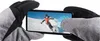 Hands wearing gloves holding a smartphone displaying a skiing scene. Náhled obrázku produktu