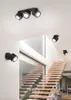A modern interior with a wooden staircase and black spotlights mounted on the wall and ceiling. Produktbild-Vorschau