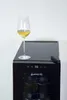 A wine cooler with a glass of white wine on top. Voir les images du produit