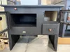 A front view of a black wood-burning stove with its doors open, showing the interior compartments. Anteprima dell’immagine prodotto
