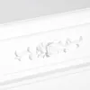A close-up of a white decorative element on a white surface. Produktbild-Vorschau