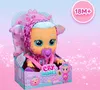 A Cry Babies doll in its packaging, with a pink and blue gradient background and glitter effects. Produktbild-Vorschau