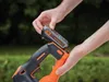A person is inserting a battery into a cordless hedge trimmer. Anteprima dell’immagine prodotto