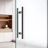 A modern interior with a glass sliding door and a silver handle, next to a wooden shelf unit. Produktbild-Vorschau