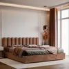 A stylish bedroom with a brown upholstered bed, dressed with pillows and a throw blanket. A contemporary pendant light hangs above a vase of dried flowers on a nightstand. Anteprima dell’immagine prodotto