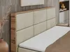 A close-up view of a beige upholstered headboard with a wooden frame, part of a bed. A white mattress topper is visible on the bed. Produktbild-Vorschau