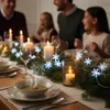 A family is enjoying a festive meal, with a table decorated with candles and snowflake lights. Náhled obrázku produktu
