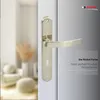 A close-up of a nickel-colored door handle on a white door, with a blurred interior scene in the background. Produktbild-Vorschau