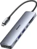 A gray USB-C hub with multiple ports and a braided cable is shown against a white background. Produktbild-Vorschau