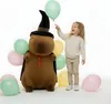 A young girl is interacting with a large plush toy capybara dressed as a wizard, surrounded by balloons. Náhľad obrázku produktu