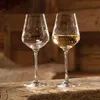 Two wine glasses on a wooden surface, with a rustic wooden background. Náhľad obrázku produktu