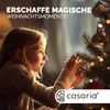 A young girl decorates a Christmas tree. Produktbild-Vorschau