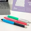 Three colorful pens are laid out on a white surface, with a laptop and a calendar in the background. Anteprima dell’immagine prodotto