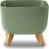 A green planter with wooden legs on a white background. Voir les images du produit