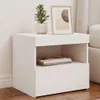 A white nightstand with a plant and a framed picture on top, placed on a wooden floor next to a wall. Produktbild-Vorschau