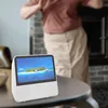 A person is dancing in the background while a portable DVD player is on a table in the foreground. Náhľad obrázku produktu