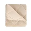 A folded beige blanket with a cream-colored inner lining, showing a quilted pattern. Produktbild-Vorschau