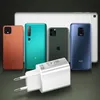 A white USB charger is in the foreground, with several smartphones and a tablet behind it. Podgląd zdjęcia produktu