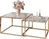 A set of two nesting coffee tables with glass tops and gold-colored metal frames, decorated with a vase of flowers and decorative objects. Produktbild-Vorschau