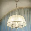A white chandelier hangs from a ceiling, with sheer curtains in the background. Podgląd zdjęcia produktu