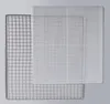 A stainless steel drying rack is partially covered by a white plastic mesh tray. Podgląd zdjęcia produktu