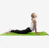 A woman is performing a yoga pose on a yoga mat. Produktbild-Vorschau